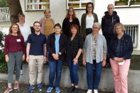 Eine Gruppe von engagierten Personen posiert lächelnd für ein Foto, das die erfolgreiche Nachbarschaftshilfe zeigt.