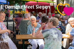 Teilnehmer genießen den ersten Demenz Meet Siegen am 11. Juli 2026 unter bunten Zelten und in fröhlicher Atmosphäre.